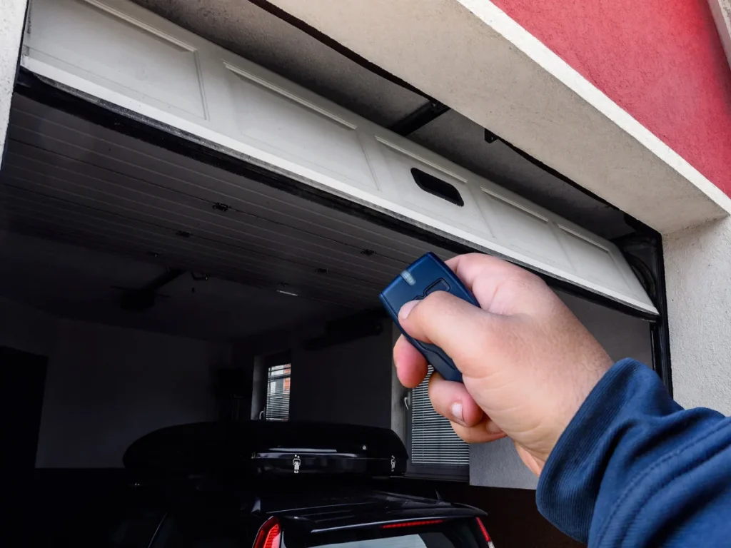 a man attempting to close a garage door using a remote